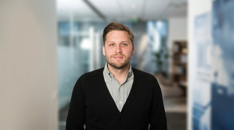 Henrik Eriksson står i en korridor.