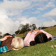 Two girls are lying in a meadow and looking at the sky.