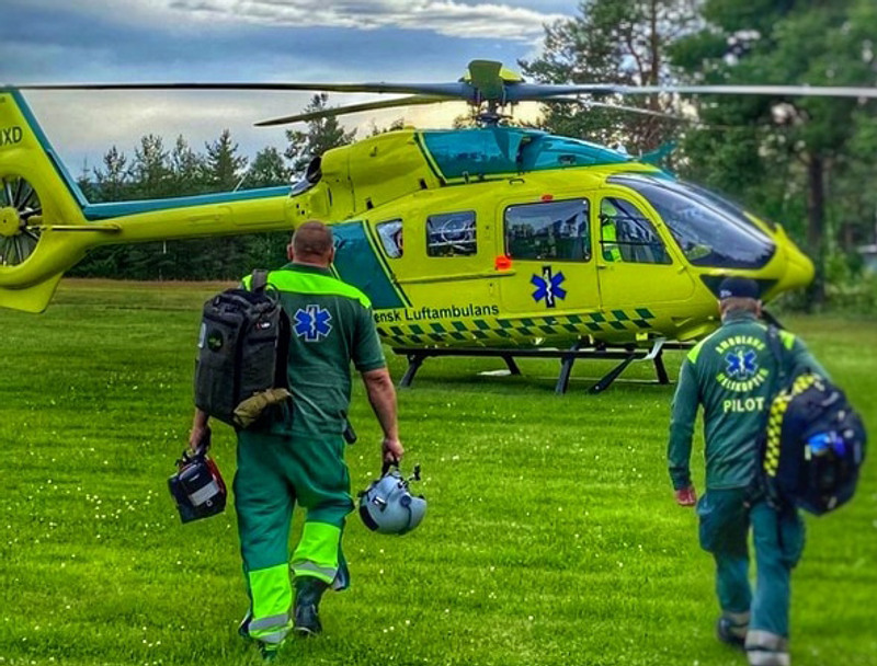 Två sjukvårdare på väg mot en ambulanshelikopter.
