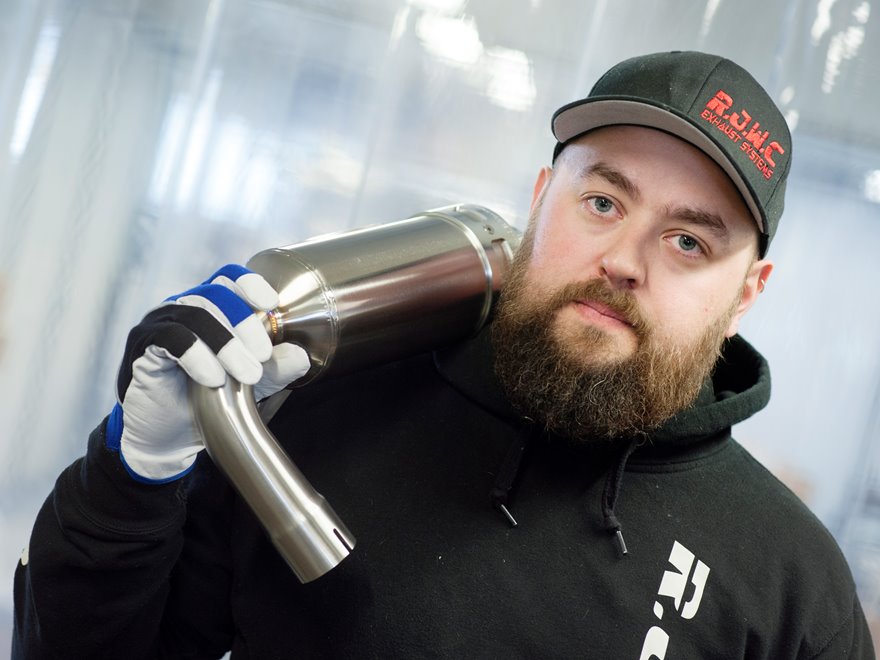 Man håller i ett avgassystem