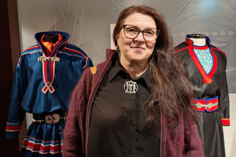 Lisa Tapio Pittja med sina två egna bidrag till utställningen, en blå herrkolt för en man och en svart damkolt.