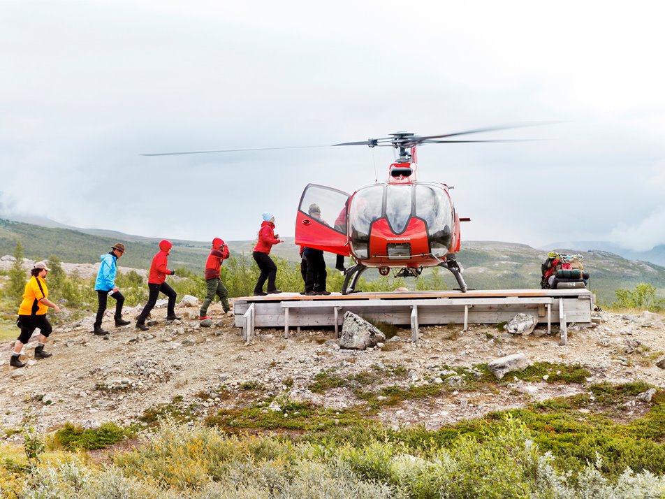 Röd helikopter på landningsplatta
