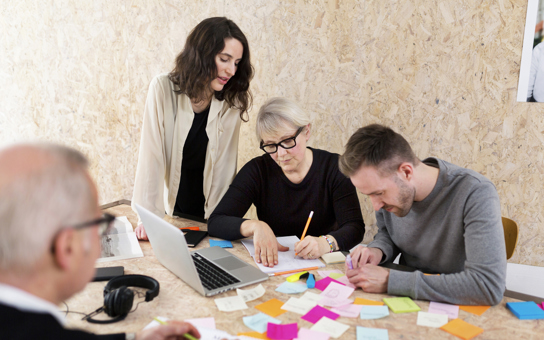 Arbetskollegor grupparbetar vid ett bord.