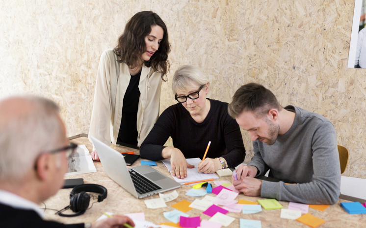 Arbetskollegor grupparbetar vid ett bord.