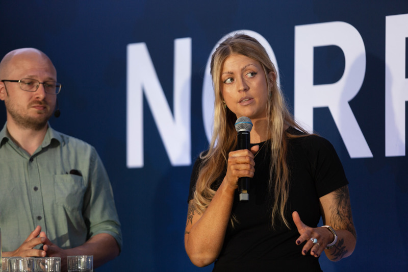 Sofie Eriksson håller mikrofon och talar medan Erik Ottoson lyssnar.