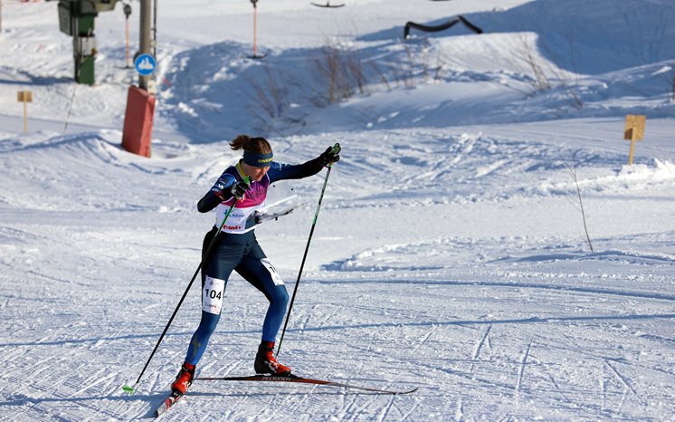Kvinna tävlar i skidorientering.