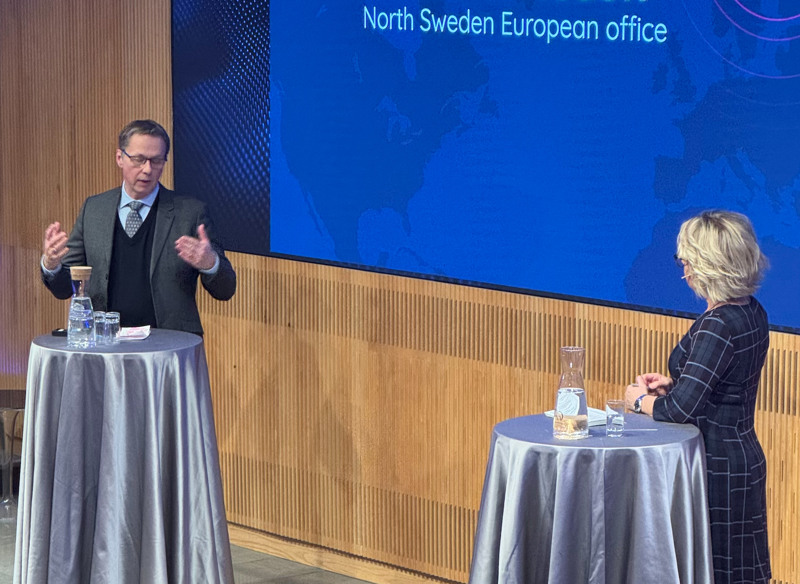 Mikael Janson står på scen och talar med Karin Hübinette