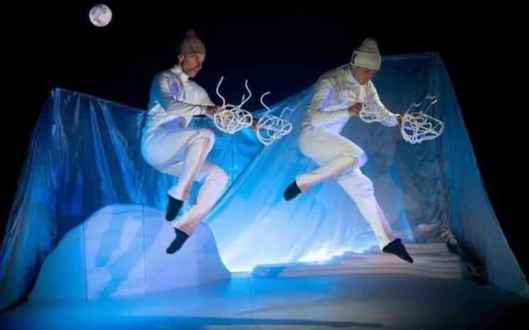 Artistisk dans utförs av två vitklädda personer.