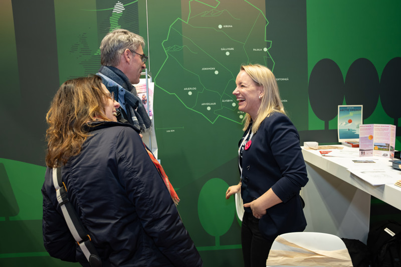 Jessica Wennberg och två mässbesökare skrattar i Arctic Sweden-montern.