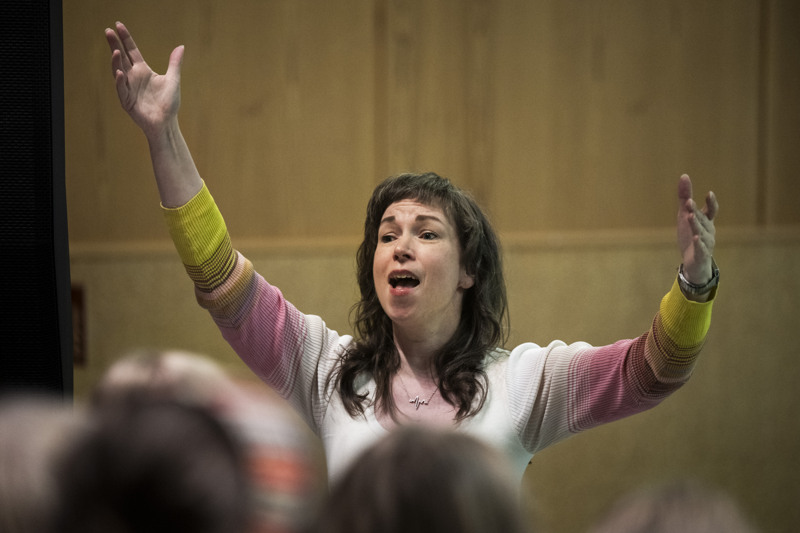 Kvinna dirigerar en kör.