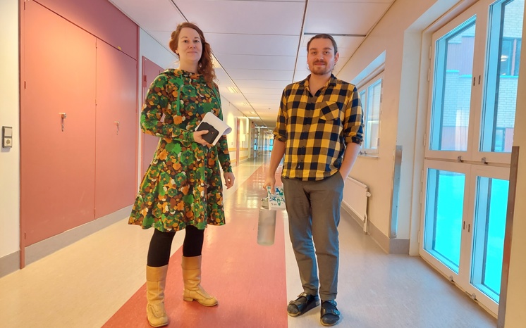 En kvinna och en man står i en korridor.