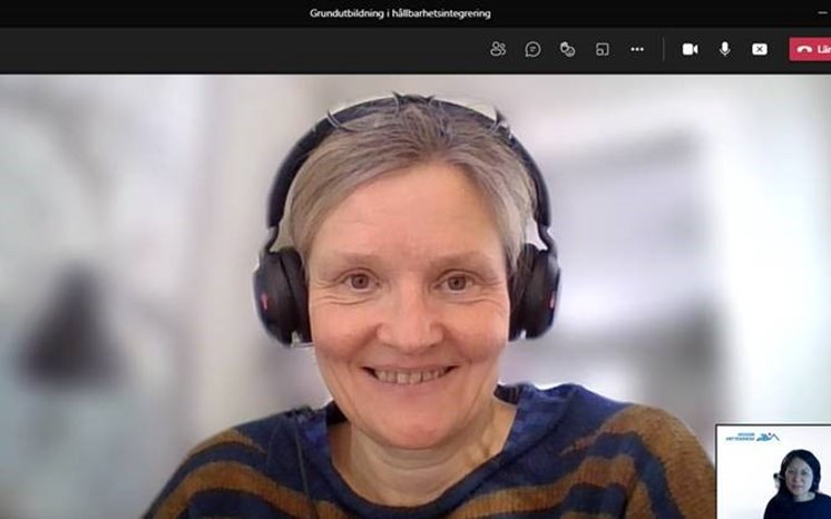 Kvinna med hörlurar deltar i digitalt möte.