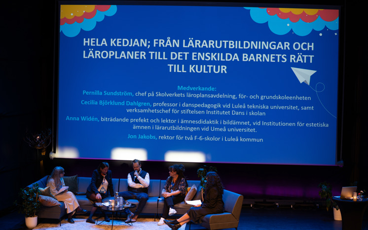 Konferensscenen med panel i soffan och en skärm om ämnet, som är hela kedjan från läroplan och läroutbildning till kulturupplevelse.