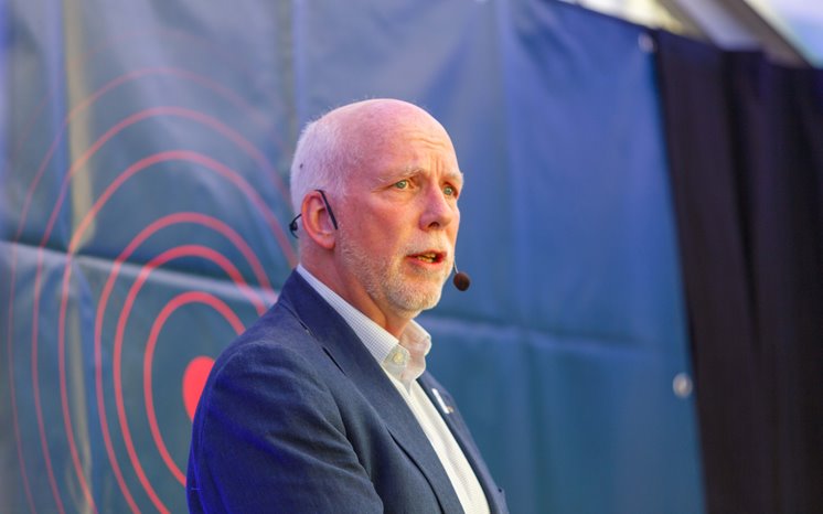 Anders Öberg står på scen framför skärm där det står Norra Scen, talar i mikrofon.