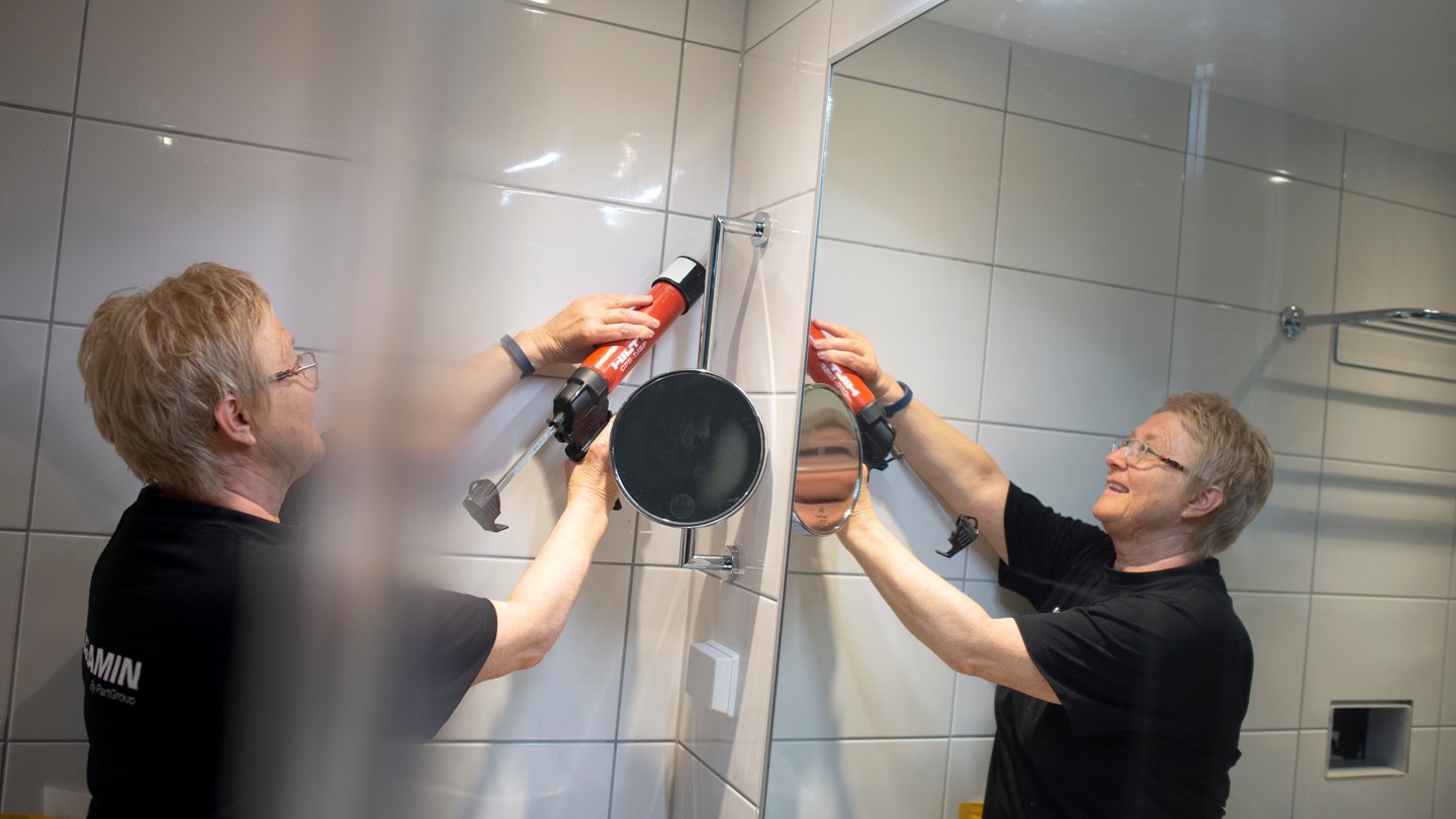 Kvinna sätter silikon i badrum
