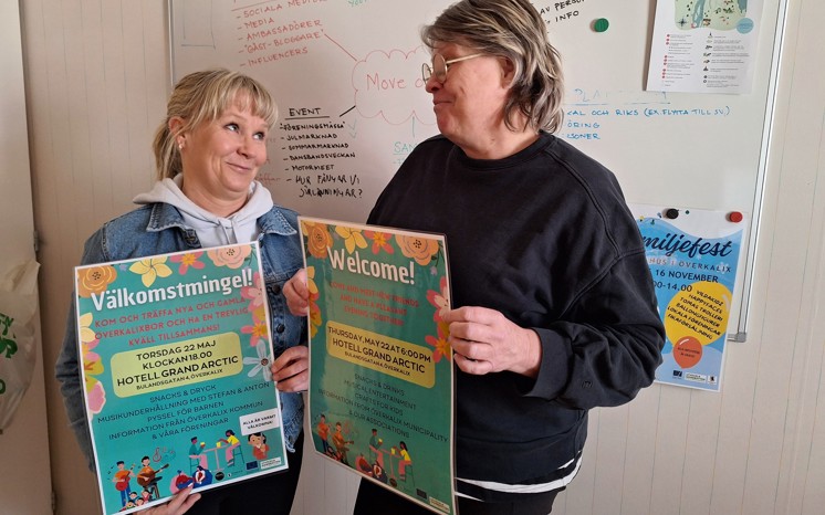 Sofi Wiippa Lahti och Sara Söderberg håller affischer som bjuder in till välkomstmingel