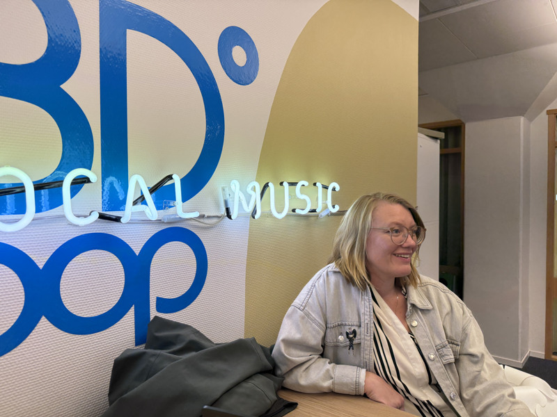 Elin Grunditz, vd BD Pop, sitter framför en väggmålning med bolagets logotyp.