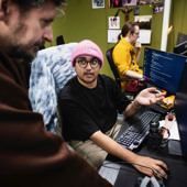 Två män pratar vid datorskärm.