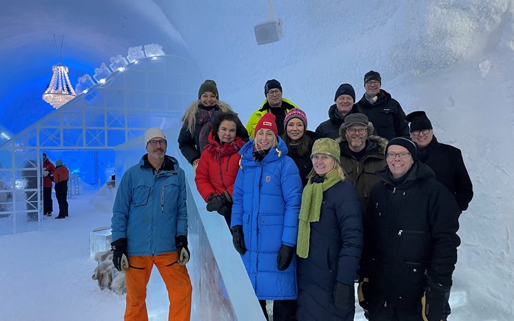 En grupp människor står i istrappan på Icehotel