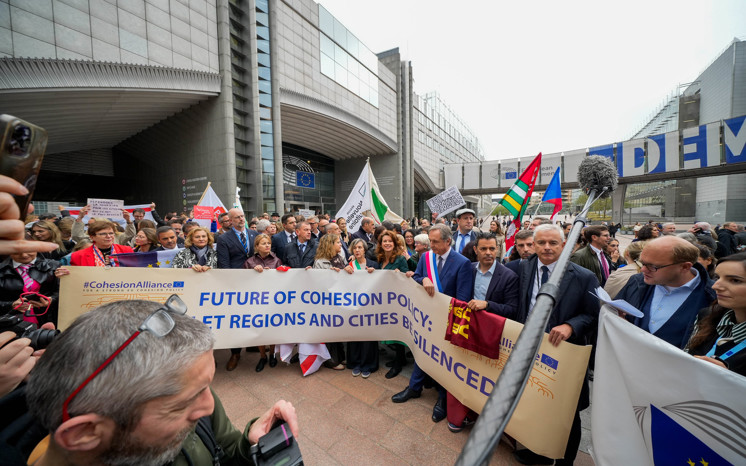 Demonstranter med en banderoll med texten: Future of cohesion policy: don't let regions and cities be silenced