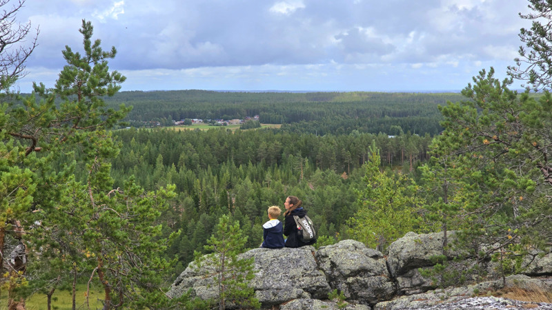 Barn och vuxen blickar ut över utsikten från Högberget.