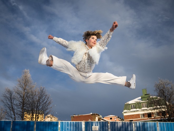 Dansaren Fanny Kivimäki i ett danssprång i ett bostadsområde i Kiruna.